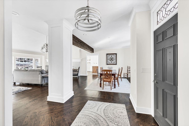 entrance foyer with ornate columns, dark hardwood / wood-style flooring, vaulted ceiling with beams, and a chandelier