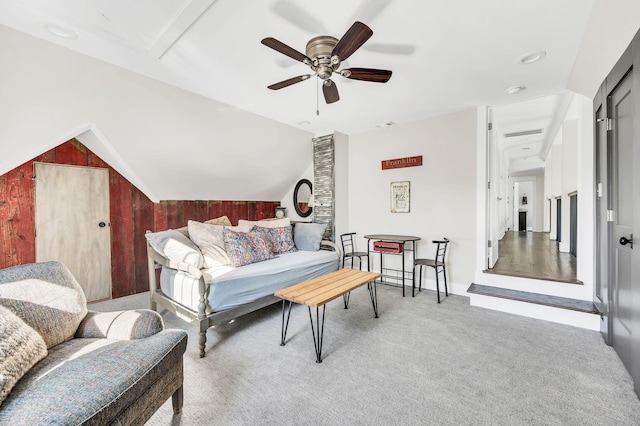 carpeted living room with ceiling fan and vaulted ceiling