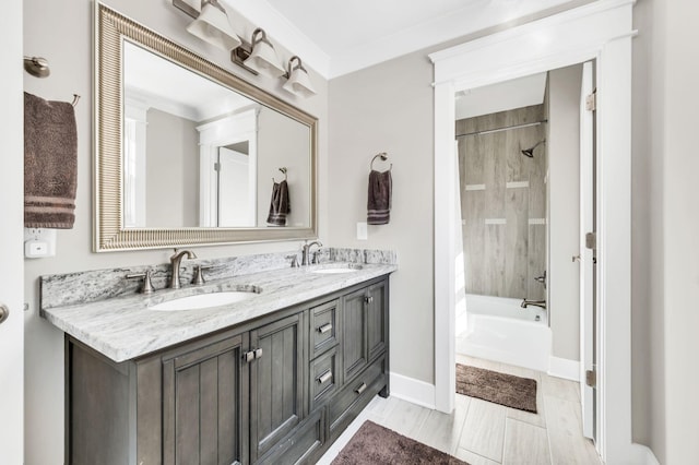 bathroom with tiled shower / bath, vanity, and ornamental molding