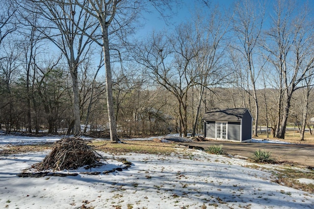 yard layered in snow featuring an outdoor structure