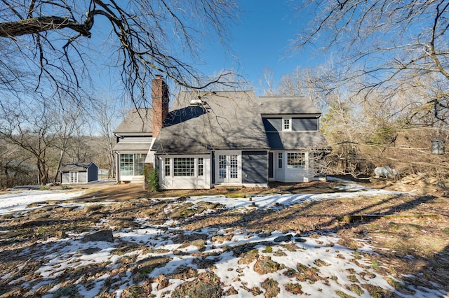 snow covered property featuring a shed