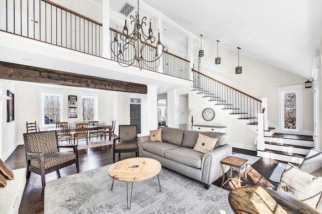 living room with wood-type flooring, a towering ceiling, and a chandelier