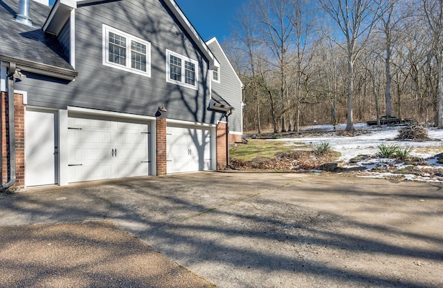 view of snow covered exterior with a garage