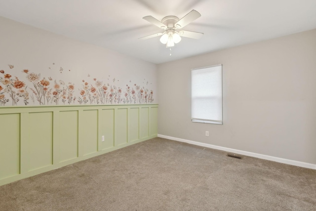 carpeted spare room with ceiling fan