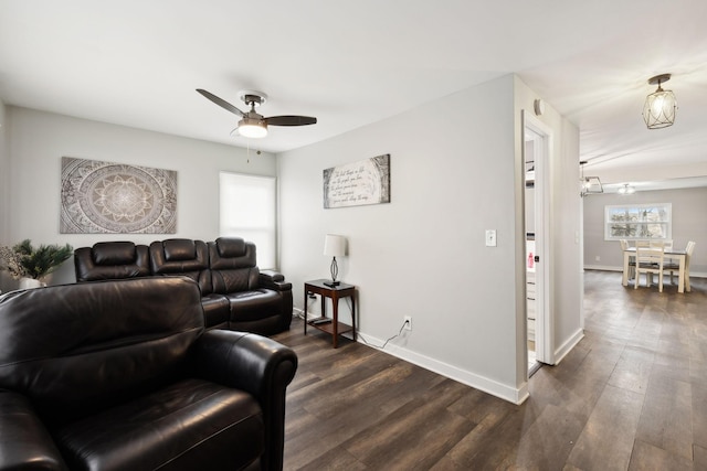 living room with dark wood-type flooring and ceiling fan