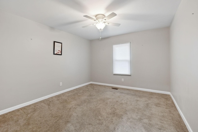 carpeted spare room with ceiling fan