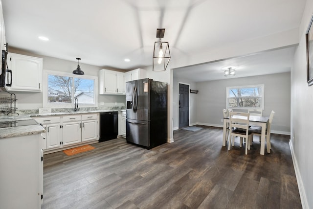 kitchen with hanging light fixtures, dishwasher, white cabinets, and stainless steel fridge