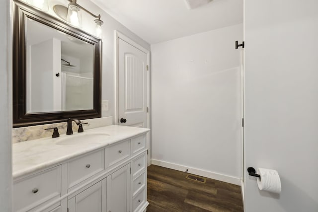 bathroom with vanity, hardwood / wood-style floors, and walk in shower