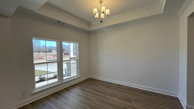 empty room with a chandelier, ornamental molding, a raised ceiling, and dark wood-type flooring