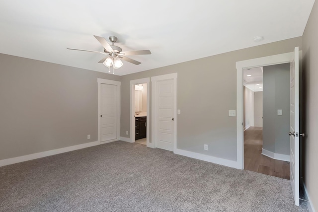 unfurnished bedroom featuring ceiling fan, ensuite bath, and light carpet