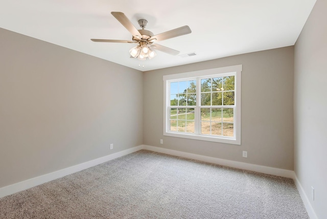 carpeted spare room featuring ceiling fan