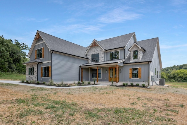 view of front facade with covered porch, a front yard, and central air condition unit