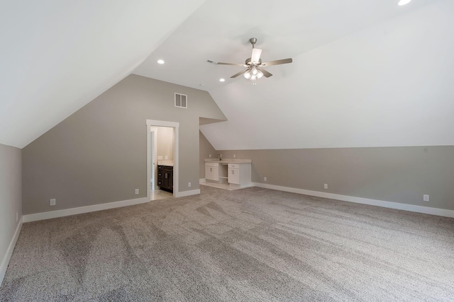 additional living space featuring lofted ceiling, sink, light carpet, and ceiling fan