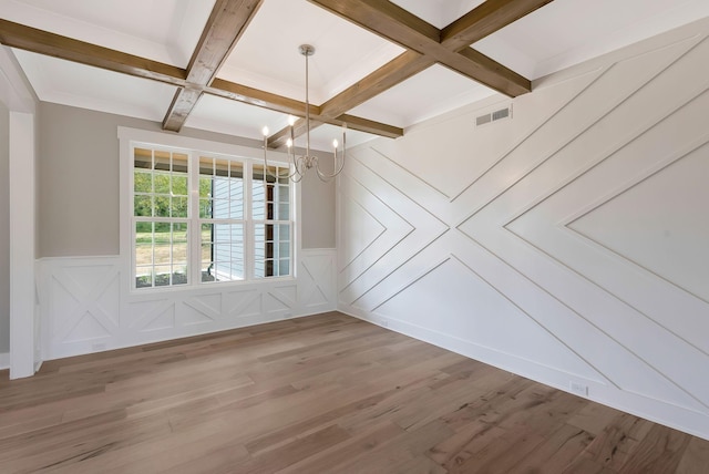 unfurnished room featuring coffered ceiling, hardwood / wood-style flooring, beamed ceiling, and an inviting chandelier