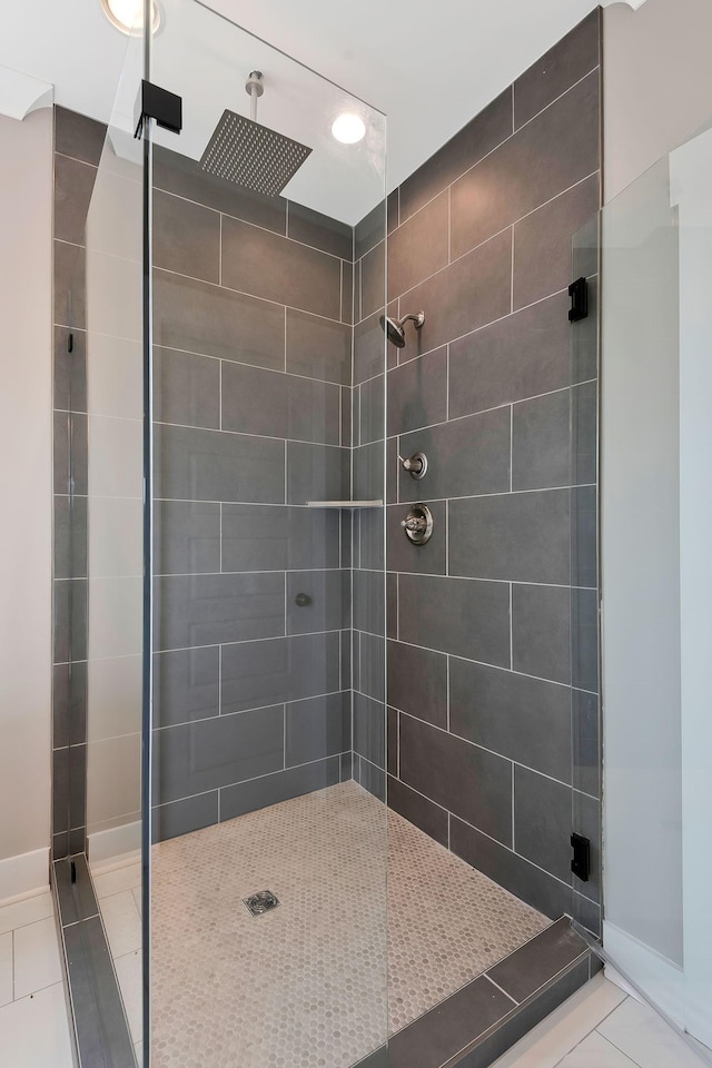 bathroom with a tile shower and tile patterned floors