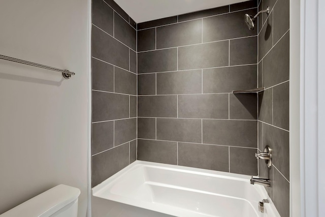 bathroom with toilet and tiled shower / bath combo