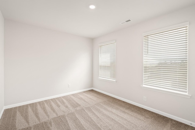 carpeted spare room featuring a wealth of natural light