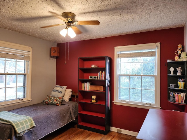 bedroom featuring hardwood / wood-style floors, a textured ceiling, and ceiling fan