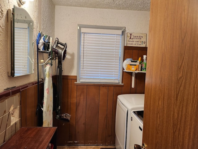 laundry room with separate washer and dryer and a textured ceiling