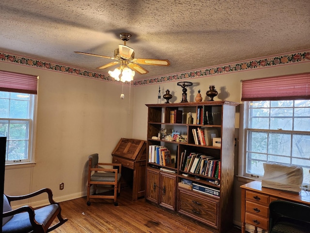 living area featuring a textured ceiling, wood-type flooring, and ceiling fan