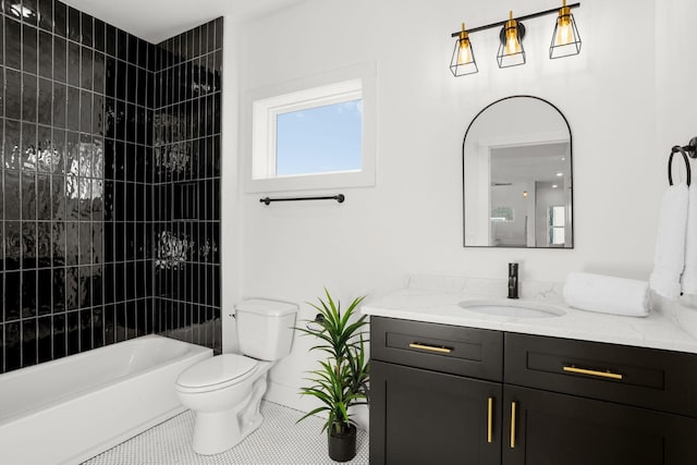 full bathroom featuring tile patterned flooring, tiled shower / bath, vanity, and toilet