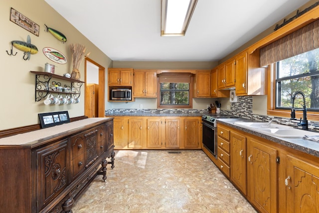 kitchen featuring tasteful backsplash, a healthy amount of sunlight, appliances with stainless steel finishes, and sink