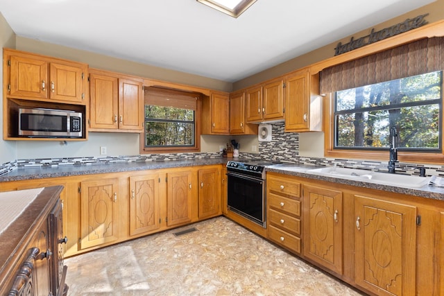 kitchen with tasteful backsplash, sink, and electric range