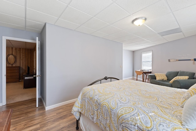 bedroom featuring wood-type flooring and a paneled ceiling