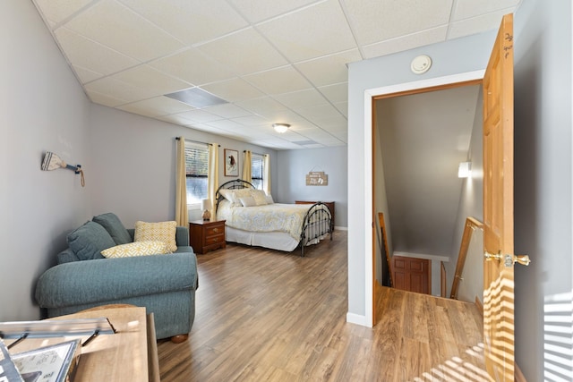 bedroom featuring hardwood / wood-style flooring and a drop ceiling