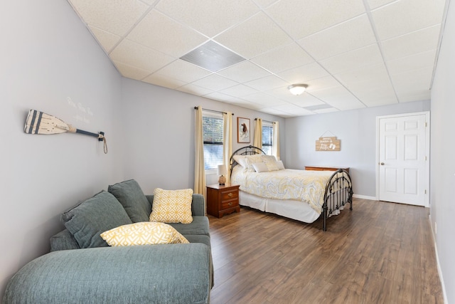 bedroom featuring dark wood-type flooring and a paneled ceiling