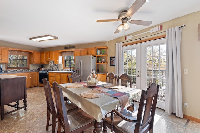 dining space featuring sink, french doors, and ceiling fan