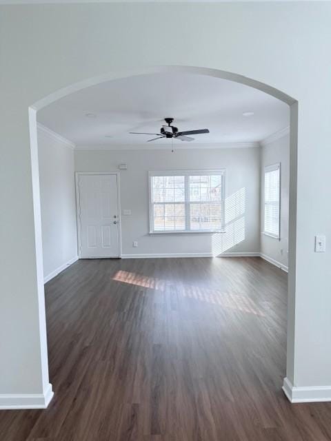 unfurnished living room featuring ceiling fan, ornamental molding, and dark hardwood / wood-style flooring