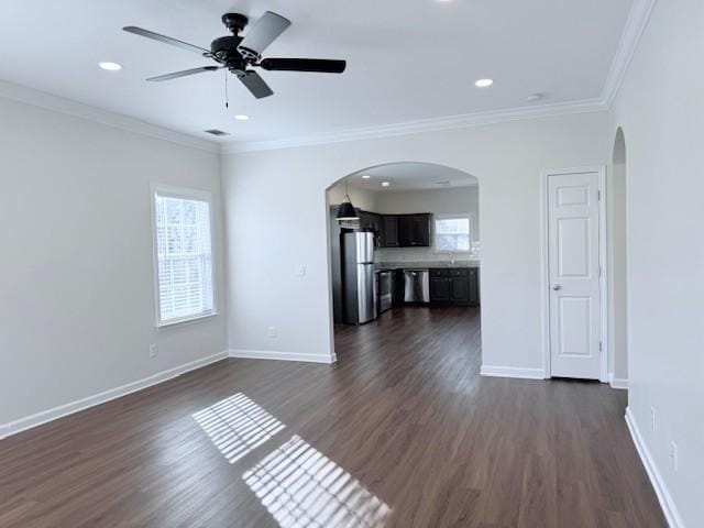 unfurnished living room featuring ornamental molding, dark hardwood / wood-style floors, sink, and ceiling fan