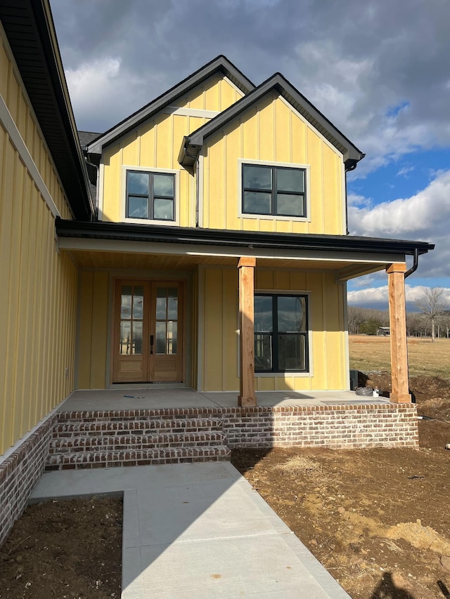 view of front facade featuring covered porch and french doors