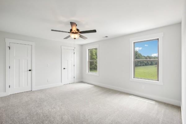 carpeted spare room featuring ceiling fan