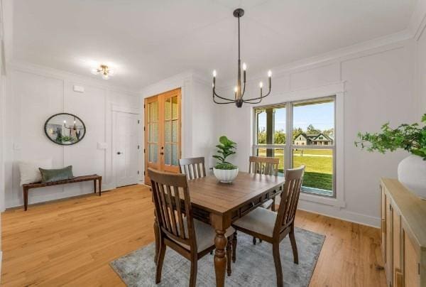 dining area featuring wood-type flooring, crown molding, and a chandelier