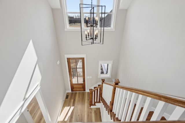 staircase featuring a chandelier and hardwood / wood-style floors