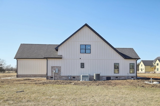 rear view of property with a yard and central AC