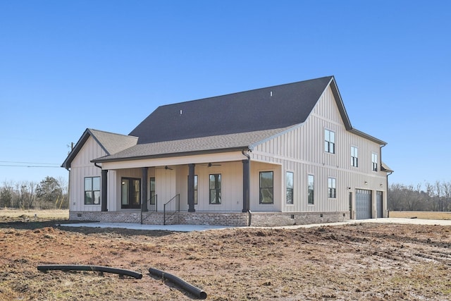 rear view of property featuring a porch and a garage