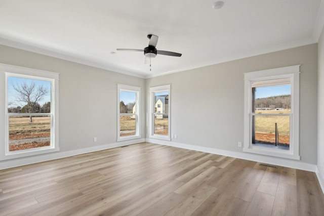 empty room featuring ornamental molding, ceiling fan, and light wood-type flooring