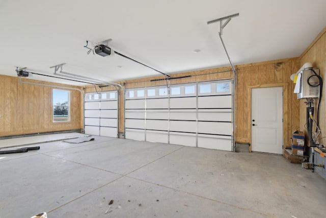 garage featuring a garage door opener and wooden walls