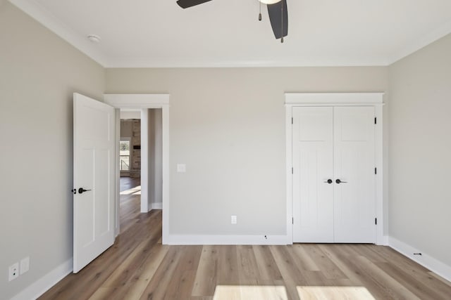 unfurnished bedroom with crown molding, a closet, ceiling fan, and light wood-type flooring