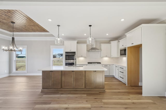 kitchen featuring built in microwave, a kitchen island with sink, white cabinets, and black gas cooktop