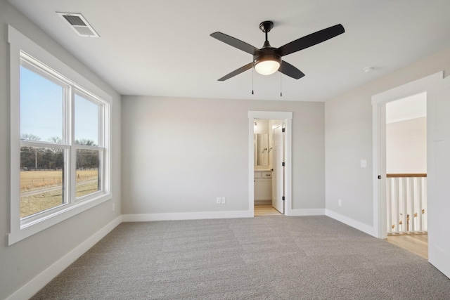 spare room featuring light carpet and ceiling fan