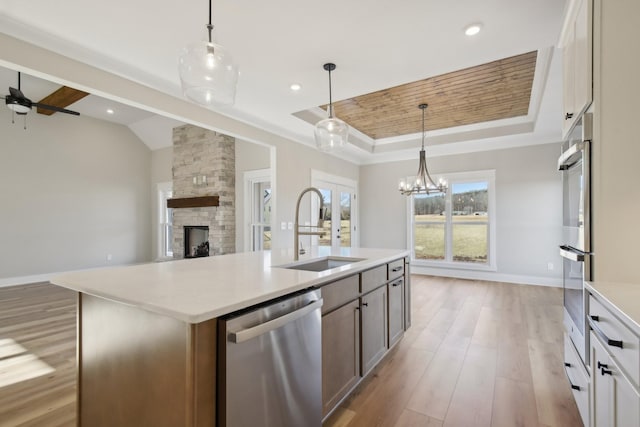 kitchen featuring stainless steel appliances, sink, white cabinets, and a kitchen island with sink