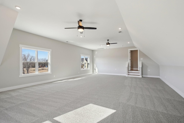 additional living space featuring light colored carpet and vaulted ceiling