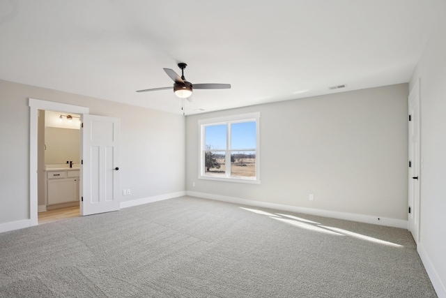 unfurnished bedroom with ensuite bath, light colored carpet, and ceiling fan