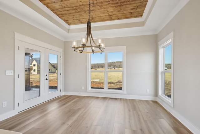 unfurnished dining area with a tray ceiling, wooden ceiling, french doors, and light wood-type flooring