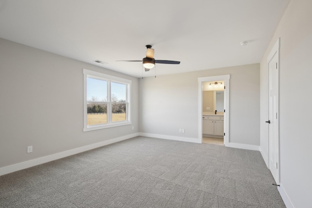 unfurnished bedroom featuring ceiling fan, ensuite bathroom, and light carpet