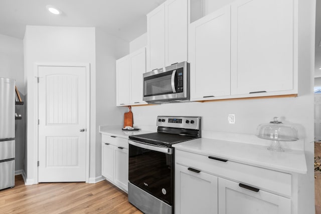 kitchen with white cabinetry, light hardwood / wood-style flooring, and stainless steel appliances